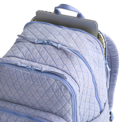 Quilted blue backpack with a laptop inside on a white background