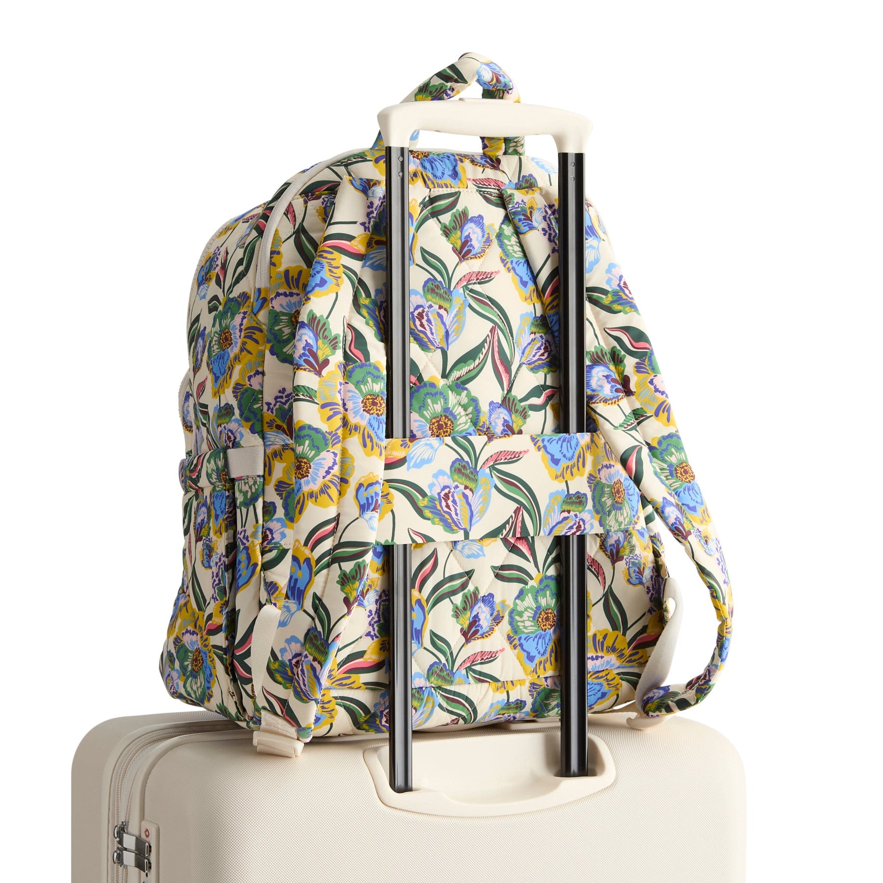 Floral-patterned backpack on a suitcase with a white background