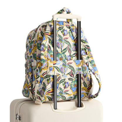 Floral-patterned backpack on a suitcase with a white background